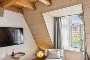 a room with a white chair and a window at Aaacentralriversidepenthousewbalcony&waterview in Zürich