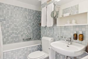 a bathroom with a white toilet and a sink at Aaacentralriversidepenthousewbalcony&waterview in Zürich +15 photos