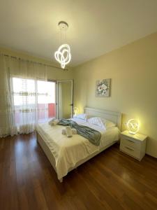 ein Schlafzimmer mit einem Bett und einem Kronleuchter in der Unterkunft Shkodra Central Corner in Shkodra