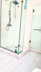 a shower with a glass door in a bathroom at Share with Jayz in Lekki