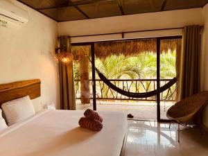 un letto con un orsacchiotto in una camera da letto di Amarbacalar a Bacalar Altre 29 foto