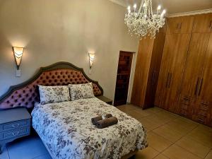 a bedroom with a bed with a stuffed animal on it at Chandané Guesthouse in Thabazimbi