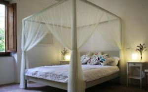 una camera con letto a baldacchino e tende bianche di Villa Vittorio a Bagni di Lucca