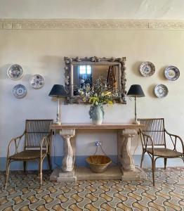 a dining room with a table with two chairs and a mirror at Maison des Frères Leglise in Miélan