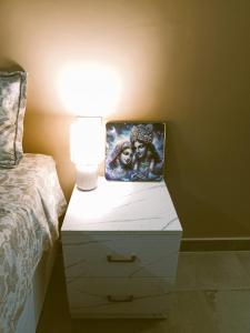 a nightstand with a lamp on it next to a bed at Krishna's Paradise in Rishīkesh