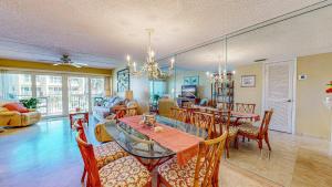 Un comedor y una sala de estar con mesa y sillas. en Pier Point Ocean View Unit D-52, en St. Augustine Beach