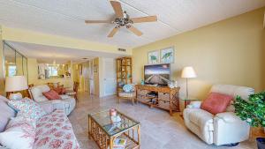 Una sala de estar con sofás y un ventilador de techo. en Pier Point Ocean View Unit D-52, en St. Augustine Beach