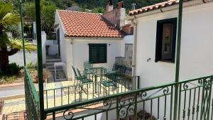 a balcony with green chairs and a white house at Acquafredda Ritrovata in Acquafredda