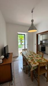 a dining room with a table and a kitchen at Acquafredda Ritrovata in Acquafredda +21 photos