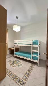 a room with two bunk beds and a rug at Acquafredda Ritrovata in Acquafredda