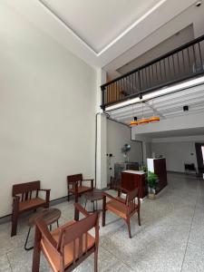 a room with wooden chairs and a loft at Laloon Guesthouse in Hat Yai