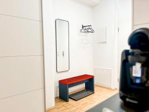ハイルブロンにあるStylisches Business Apartment nähe Bildungscampus Heilbronnの鏡付きの部屋の椅子に座る者