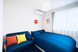 - une chambre avec un canapé bleu et une fenêtre dans l'établissement 夢富良野, à Furano