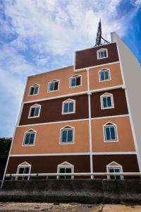 a tall brown and white building with a sky at Hotel Sree in Tiruchchirāppalli