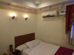 a bedroom with a bed and a air conditioner on the wall at Hotel Sree in Tiruchchirāppalli