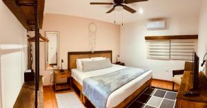 a bedroom with a bed and a ceiling fan at Casa Bene Villas in Isla Mujeres