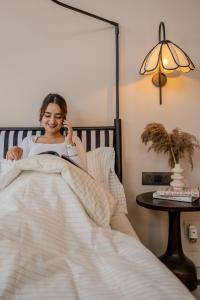 a woman laying in bed talking on a cell phone at 3000Sqft Ultra Luxury Apartment with Private Cinema In Delhi Poshest Locality Greater Kailash 2 in Jāmb