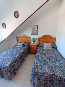 two beds sitting next to each other in a bedroom at Apartamento de 3 Habitaciones y un baño SIN cocina en San Vicente de O Grove in San Vicente de O Grove