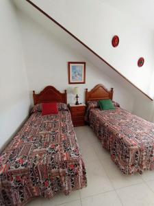 two beds sitting next to each other in a bedroom at Apartamento de 3 Habitaciones y un baño SIN cocina en San Vicente de O Grove in San Vicente de O Grove