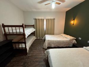 une chambre avec deux lits et un ventilateur de plafond dans l'établissement Canto da Seriema, à Socorro 109 autres photos