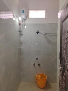 a bathroom with a shower with a bucket in it at SWASTIK STAY Ac and Non Ac Rooms in Raigīr