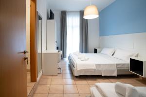 a hotel room with two beds and a bathroom at Hotel Minerva in Caorle
