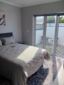 een slaapkamer met een bed en een balkon met een tafel bij Da Gama Villa in Marina da Gama