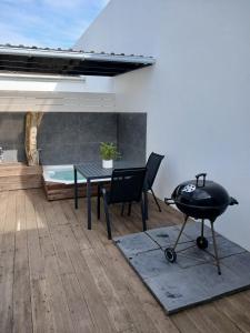 een terras met een tafel, een grill en een bad bij Da Gama Villa in Marina da Gama