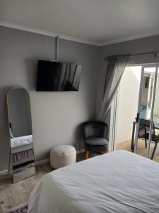 een slaapkamer met een bed en een tv aan de muur bij Da Gama Villa in Marina da Gama