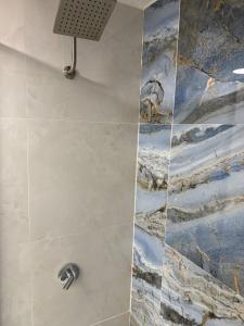 La salle de bains est pourvue d'une douche et d'une peinture murale. dans l'établissement Relaxing Coast - 7, à Arroyo