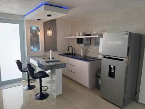 a kitchen with a refrigerator and a sink in it at Relaxing Coast - 7 in Arroyo