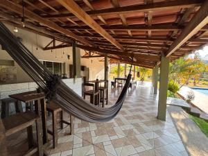 - un hamac sur une terrasse avec des tables et des chaises dans l'établissement Canto da Seriema, à Socorro