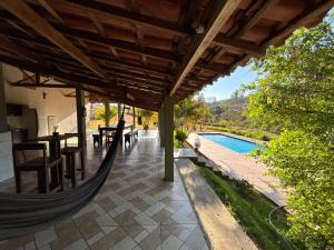 - un hamac sur la terrasse d'une maison avec piscine dans l'établissement Canto da Seriema, à Socorro
