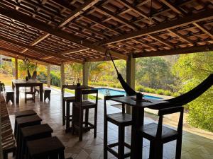 un restaurant avec des tables et des chaises et une piscine dans l'établissement Canto da Seriema, à Socorro