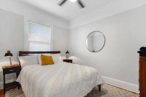 a white bedroom with a bed and a mirror at SaraCasa - First Floor House 2Br/1.5Bath in St. Augustine