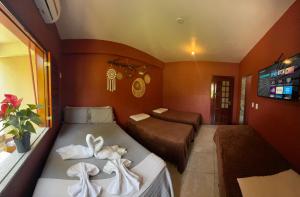 um pequeno quarto com duas camas e uma tv em Vila icarai em Caucaia mais 21 fotografias