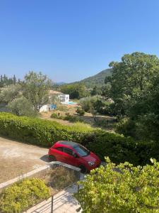 a red car parked in a parking lot at Aux portes des Cévennes in Saint-Hippolyte-du-Fort