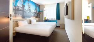 a hotel room with two beds and a window at B&B HOTEL Krakow Centrum in Kraków