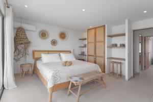 a white bedroom with a bed and a table at Villa Coco in Oyster Pond +31 photos