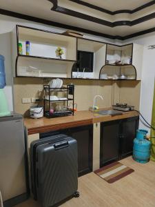 a kitchen with a refrigerator and a counter top at Nanay Bebs Guesthouse in General Luna