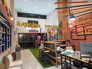 a restaurant with tables and chairs and a brick wall at MT friendhome&hostel2 in Phuket