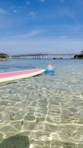 two surfboards sitting in the water near a pier at Nanay Bebs Guesthouse in General Luna