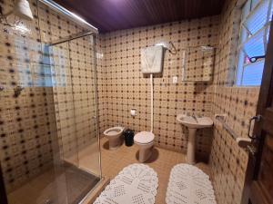 a bathroom with a shower and a toilet and a sink at Pousada Pedra da Gávea in Visconde De Maua +135 photos