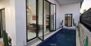 a swimming pool in the middle of a house at Villa Cozy Kapal 1BR private pool in Badung