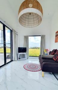a living room with a couch and a chandelier at Villa Cozy Kapal 1BR private pool in Badung