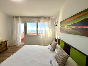 a bedroom with a large bed with a view of the ocean at Holibai Albatros, Dúplex al ladito del Mar, con terrazas y piscina, Baiona in Baredo +32 photos