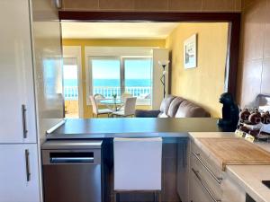 a kitchen with a view of a living room at Holibai Albatros, Dúplex al ladito del Mar, con terrazas y piscina, Baiona in Baredo