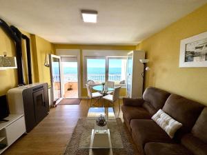 a living room with a couch and a view of the ocean at Holibai Albatros, Dúplex al ladito del Mar, con terrazas y piscina, Baiona in Baredo