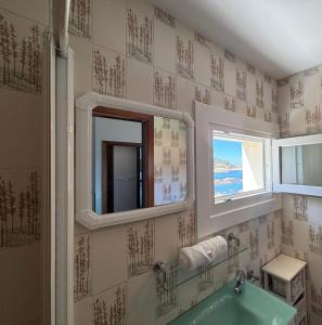 a bathroom with a green tub and a mirror at Holibai Albatros, Dúplex al ladito del Mar, con terrazas y piscina, Baiona in Baredo