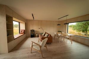 a living room with a couch and a table and chairs at Casa Hikari - Lofoten Retreat in Vestvågøya